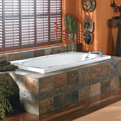 A standalone tub with a patterned stone base. 