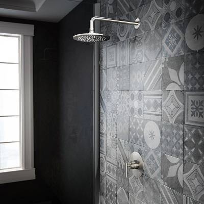 An elegant walk-in shower with decorative black-and-white wall tiles. 