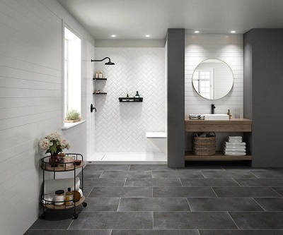 A large bathroom with a Roman walk-in shower, gray slate flooring and a craftsman-style vanity with a round mirror. 